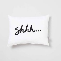 a white pillow with the word shh printed in black on it's side