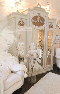 a living room with white furniture and chandelier in the corner, all decorated for christmas