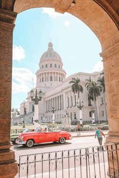 an old red car is parked in front of the capitol building