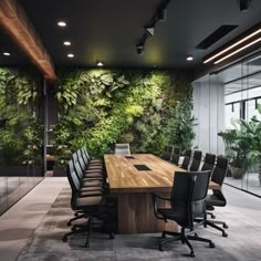 an office with a large wooden table and black chairs in front of a green wall