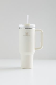 a white coffee cup with a straw in it