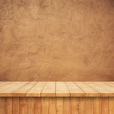 an empty wooden table in front of a brown wall with no one sitting on it