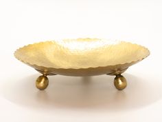 a golden bowl sitting on top of a white table