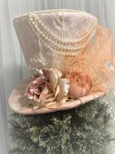 "This elegant Victorian Christmas tree topper top hat is READY TO SHIP. Use the top hat as a tree topper for the holiday season and or a decoration centerpiece for anywhere in your home throughout the year. The tree topper top hat is made as follows: *The top hat taper/body is made with ivory lace fabric. * The brim is made with mauve fabric. *The band is made with mauve lace. Decorated with: *Feather, flowers, string of pearls, lace. *10\" wide lace bow with tails at the back. * Measurements ar Victorian Christmas Centerpieces, Fancy Top Hat, Elegant Christmas Tree Toppers, Victorian Tree Topper, Victorian Cloche Hat For Weddings, Victorian Cloche Wedding Hat, Vintage Top Hat With High Crown For Wedding, Vintage High Crown Top Hat For Wedding, Vintage White Top Hat For Wedding