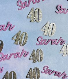 some pink and silver numbers are on a blue background with white letters that spell out the number forty