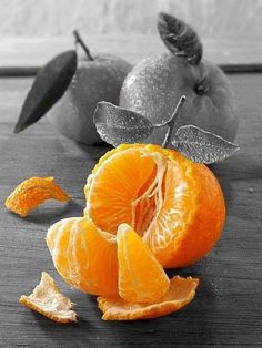 an orange cut in half sitting on top of a table next to other pieces of fruit