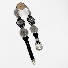 Indulge in the elegant and exclusive style with our Lyra Concho Belt. Made from luxurious black Italian leather, this western-style belt features intricate silver concho hardware and stud details. The silver buckle set adds the perfect finishing touch. Elevate any outfit and make a statement with this sophisticated accessory. Details: Smooth black Italian leather Silver plated buckle set and hardware Sourced in Italy Made in California Luxury Black Embroidered Belt, Western Black Belt Buckle With Belt, Black Belt With Antique Buckle For Rodeo, Western Black Belt Buckles, Western Black Belt Buckles For Rodeo, Southwestern Style Concho Belt For Festivals, Western Style Black Belt For Ranch, Silver Southwestern Concho Belt, Silver Concho Belt Buckles For Festival