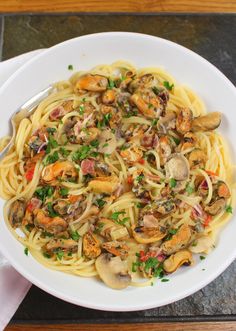 a white bowl filled with pasta covered in mushrooms