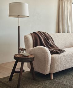 a living room with a couch, table and lamp