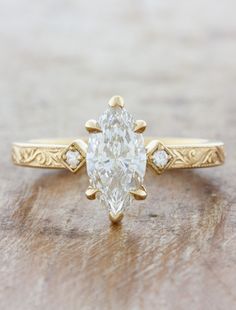 a close up of a ring with a diamond on the top and an oval shaped stone in the middle