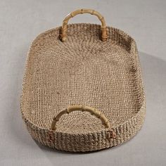 a woven basket with wooden handles on a table