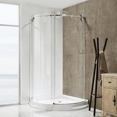 a bathroom scene with focus on the corner shower stall and floor to ceiling glass doors