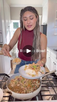 a woman sitting on top of a stove in front of a pan filled with food