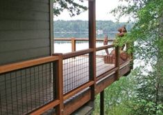 there is a wooden deck on the side of this house that overlooks a lake