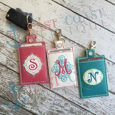 three personalized key fobs with monogrammed initials on them are displayed