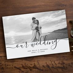 an image of the wedding announcement card on top of a wooden table