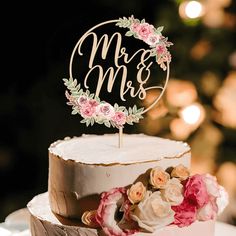 a wedding cake decorated with flowers and a mr and mrs sign