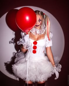 a woman dressed as a clown holding a red balloon