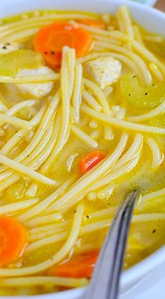 a bowl of chicken noodle soup with carrots, celery and noodles