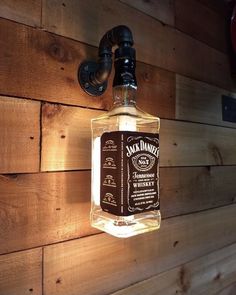 a bottle hanging from the side of a wooden wall next to a faucet