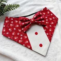 a red and white dog bow tie with flowers on it