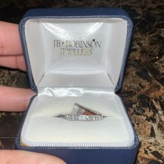 a person is holding an engagement ring in their hand and it's inside the box