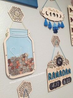 some signs hanging from the side of a wall with coins in them and other decorations