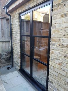 an outside view of a patio with sliding glass doors on the side of a brick building