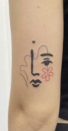 a woman's arm with a tattoo on it that has a face and four leaf clovers