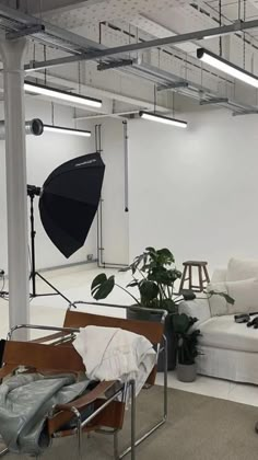 an empty room with white couches and black umbrellas