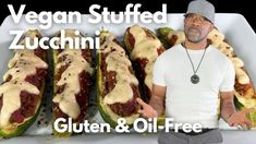 a man standing in front of a tray filled with stuffed zucchini and cheese