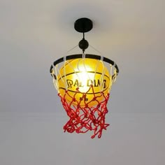 a basketball is hanging from the ceiling with red string attached to it's net