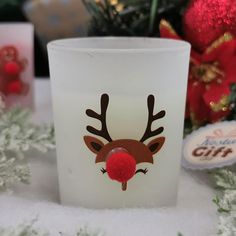 a frosted glass with a reindeer's head on it and christmas decorations in the background