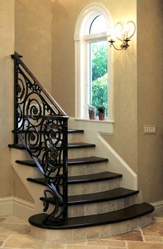 an elegant staircase with wrought iron railing