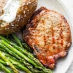 a burger and asparagus on a white plate