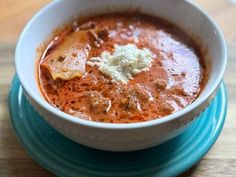 a white bowl filled with soup on top of a blue plate