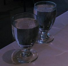 two glasses of water sitting on top of a table