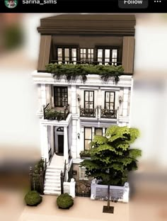 a large white house with balconies on the second floor and trees in front