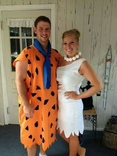 a man and woman dressed up as flint and the flintstones for halloween costume contest