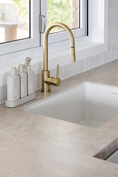 a kitchen sink with a faucet and soap dispenser