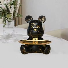 a black and gold mickey mouse figurine sitting on top of a white table