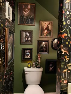 there is a toilet in the bathroom with many pictures on the wall above it and below it