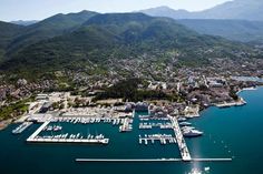 an aerial view of a marina with boats docked in the water and mountains in the background