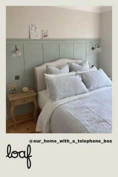 a bed with white linens and pillows in a room that is painted pale blue