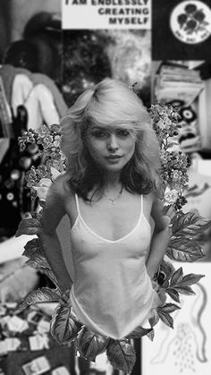 a black and white photo of a woman in a tank top with leaves on it