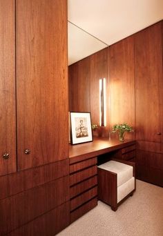 an empty dressing room with wooden walls and drawers