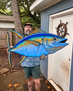 a man holding up a large blue fish