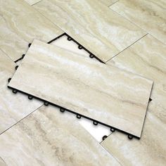 some white marble tiles with black dots on the bottom and one tile is laying down