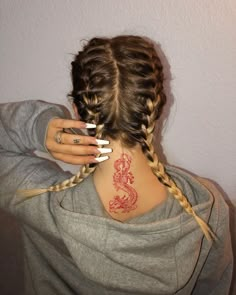 a woman with two braids in her hair and a dragon tattoo on her back