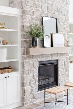 a living room with a brick fireplace and white bookcases